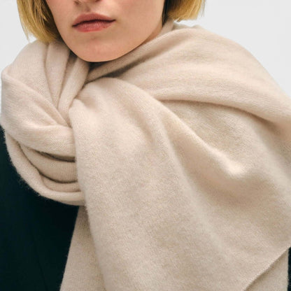 Shop Rescue Spa beige cashmere travel wrap worn as a soft, lightweight, and breathable unisex scarf.