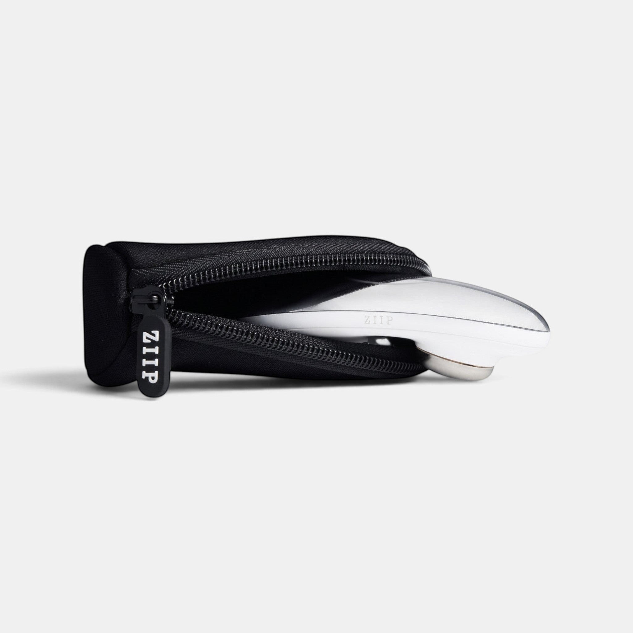 ZIIP travel bag in black neoprene with a custom ZIIP zipper pull holding a ZIIP beauty device.