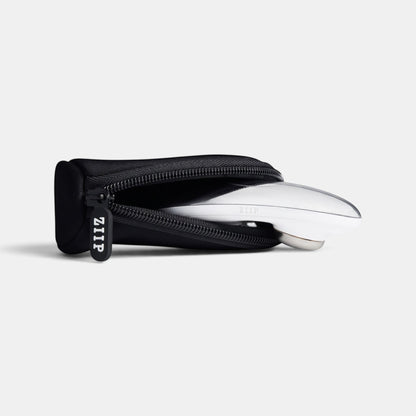 ZIIP travel bag in black neoprene with a custom ZIIP zipper pull holding a ZIIP beauty device.